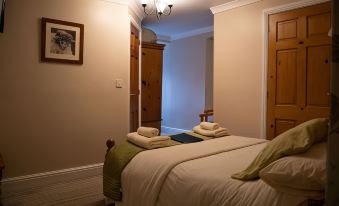 a cozy bedroom with two beds , one on the left and one on the right side of the room at Black Bull Hotel