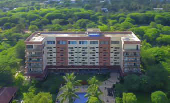 aerial view of a large hotel surrounded by trees , with a swimming pool in front of it at The Jayakarta Suites Komodo Flores