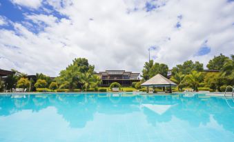 a large swimming pool with a house in the background and trees surrounding the area at Nakakiri Resort & Spa
