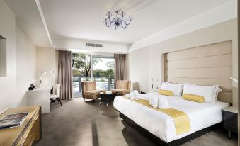 a luxurious hotel room with a large bed , a couch , a chair , and a dining table at Swan River Hotel