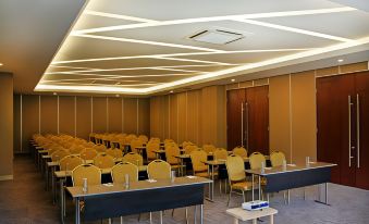 a large conference room with rows of chairs arranged in a semicircle , ready for a meeting at FamVida Hotel Lubuklinggau Powered by Archipelago