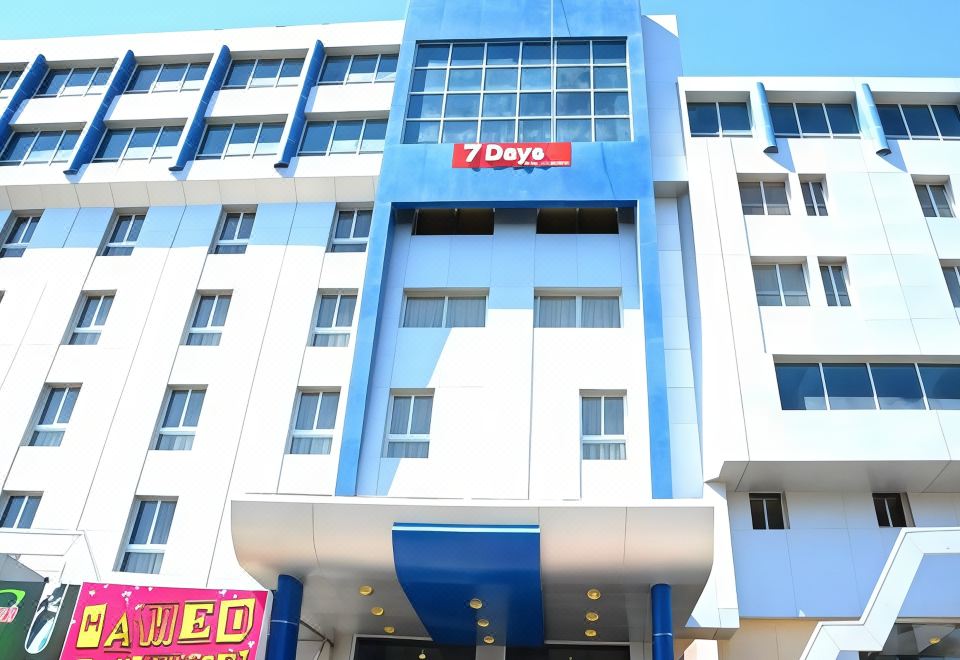 "a blue and white building with a sign that reads "" 7 days "" on the front" at Seven Days Hotel