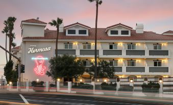 "a building with palm trees and a red sign that says "" hermosa "" in the background" at Hotel Hermosa