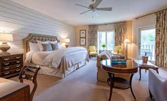 a spacious bedroom with a king - sized bed , multiple chairs , and a desk in the room at The Greystone Inn