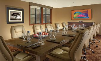 a conference room with a large table surrounded by chairs , plates , and wine glasses , along with various items on the table at The Lodge at Jackson Hole