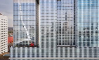 a modern building with large glass windows and a clear view of the city skyline at Nhow Rotterdam