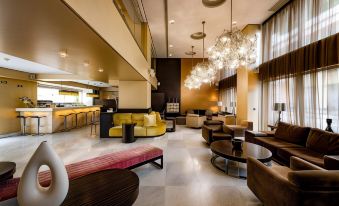 a modern hotel lobby with various seating options , including couches and chairs , as well as a bar area at Nafs Hotel