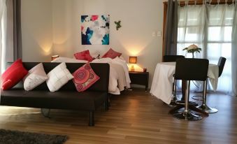 a cozy living room with a couch , a chair , and a painting on the wall at Stone Hut Cottage