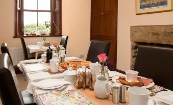 a dining table set with a variety of dishes and utensils , ready for a meal at Stanley Lodge Farmhouse