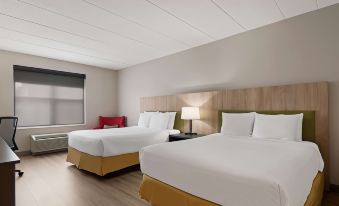 a hotel room with two beds , a nightstand between them , and a window on the left side at Country Inn & Suites by Radisson, Harrisburg Northeast - Hershey