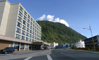 a city street with a large building in the background and a mountain in the background at Four Points by Sheraton Juneau