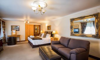 a spacious bedroom with a large bed , a couch , and a chandelier hanging from the ceiling at Woodlands