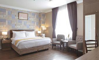 a hotel room with a large bed , two chairs , and a window , decorated in neutral colors at Forbis Hotel