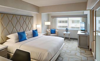 a modern hotel room with a large bed , two chairs , a desk , and a window at The Kingsley Bloomfield Hills - a DoubleTree by Hilton