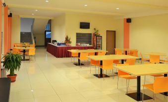a large dining room with multiple tables and chairs arranged for a group of people to enjoy a meal together at Hotel Kings Kudus