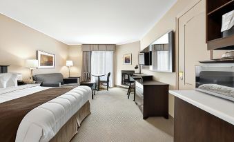 a modern hotel room with a bed , desk , and tv , along with a couch and dining table at Hotel le Versailles