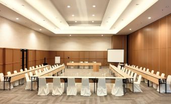 a large conference room with several rows of chairs arranged in a semicircle around a long table at Grand Cordela Hotel As Putra Kuningan