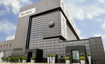 a modern building with a large black and gray facade is surrounded by potted plants at Dakota Eurocentral