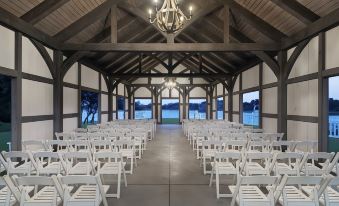 a large room with wooden beams and white chairs is set up for an event at Beaufort Hotel