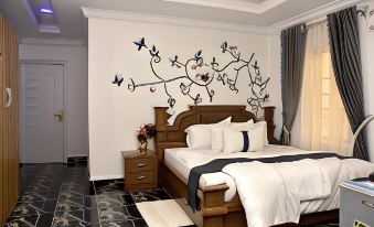a bedroom with a large bed , black and white floral design on the wall , and a black and white checkered floor at Mountain Top Lodge Hotel