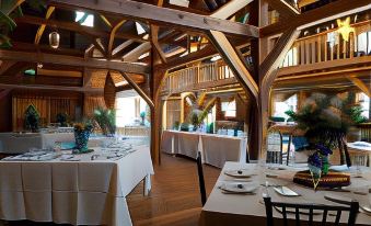 a large dining room with wooden tables and chairs arranged for a group of people at Highland Lake Inn