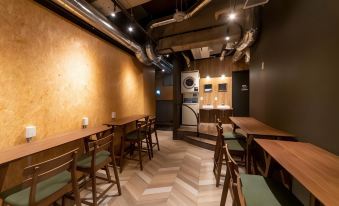 The restaurant features an interior design with wooden floors, tables, and chairs placed both in front and throughout the space at EeGee Stay Kamata