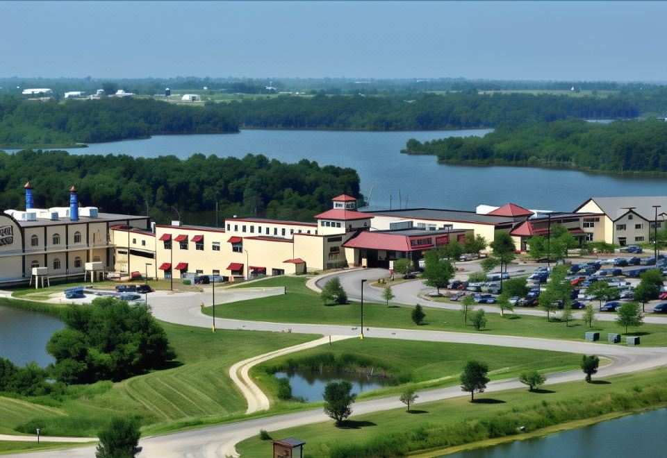 a large building surrounded by a grassy field , with a lake in the background at Lakeside Hotel Casino