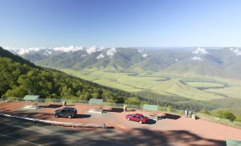 a scenic view of a mountainous landscape with cars parked on the side of the road at Bucketts Way Motel