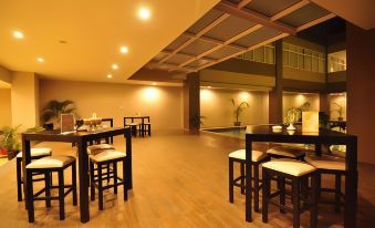 a dining room with several tables and chairs arranged for a group of people to enjoy a meal together at Pematang Siantar