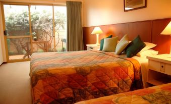 a hotel room with two beds , one on the left and one on the right side of the room at Augusta's Georgiana Molloy Motel