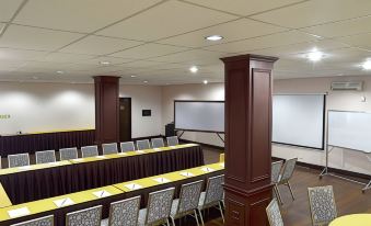 a conference room with a long table , chairs , and a projector screen , ready for a meeting or presentation at Thunderbird Resorts - Rizal