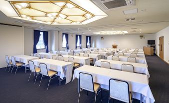 a large , empty conference room with multiple tables and chairs arranged for a meeting or event at Airline Hotel
