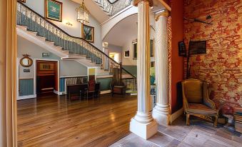 a grand staircase with a white column leading up to the second floor of a building at Melville Castle Hotel