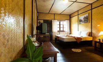 a cozy bedroom with a bed , nightstand , and desk , decorated in warm colors and wooden flooring at Nakakiri Resort & Spa