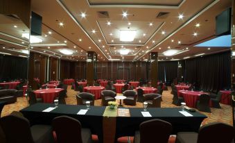 a large conference room with multiple round tables and chairs arranged for a meeting or event at Pakons Prime Hotel