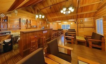 a cozy wooden interior with a bar , chairs , and tables , giving a warm and inviting atmosphere at Bluebay Beach Resort