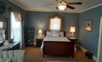 a cozy bedroom with a bed , nightstands , and lamps , as well as a ceiling fan at Barclay Bed and Breakfast