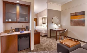 a modern hotel room with a kitchenette , bed , and desk , along with a couch and tv at SpringHill Suites Thatcher