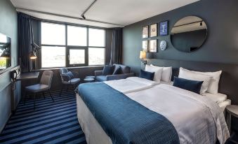a hotel room with two beds , one on the left and one on the right side of the room at Scandic Falkoner