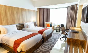 a hotel room with two beds , one on the left and one on the right side of the room at Horison Ultima Bandung