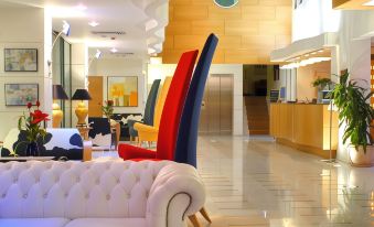 a modern living room with a white couch and colorful chairs , creating a vibrant atmosphere at Poseidon Palace