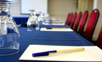 a conference table set up for a meeting , with blue tablecloths and various items on the table at Heights Hotel