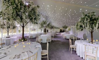 a large white tent with tables and chairs set up for an outdoor event , possibly a wedding reception at Nunsmere Hall Hotel