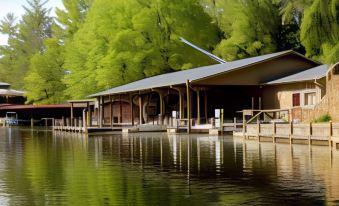 a wooden building on stilts over a body of water , surrounded by lush green trees at Lake Rabun Hotel