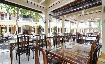 an outdoor dining area with tables and chairs arranged for a group of people to enjoy a meal together at RedDoorz Syariah @ Jalan Dieng