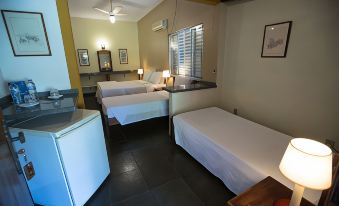 a hotel room with three beds , two of which are twin beds and one is a double bed at Hotel Fazenda Sete Lagos