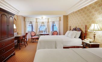 a hotel room with two beds , a dining table , chairs , and a window overlooking the ocean at The Clarkson Inn