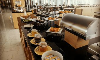 a large buffet table filled with a variety of food items , including pastries , sandwiches , and beverages at BBC Hotel Lampung Bandar Jaya