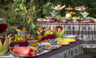 a table filled with various fruits and a variety of bowls containing different types of food at Ngorongoro Serena Safari Lodge