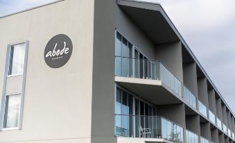 "a modern apartment building with multiple balconies , a sign for "" adade "" on the side , and a balcony overlooking the balcony" at Abode Malua Bay